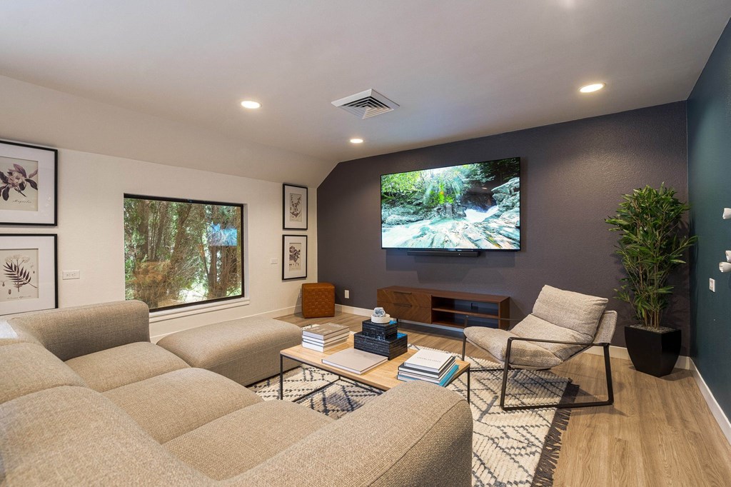 a living room with a large screen tv on the wall